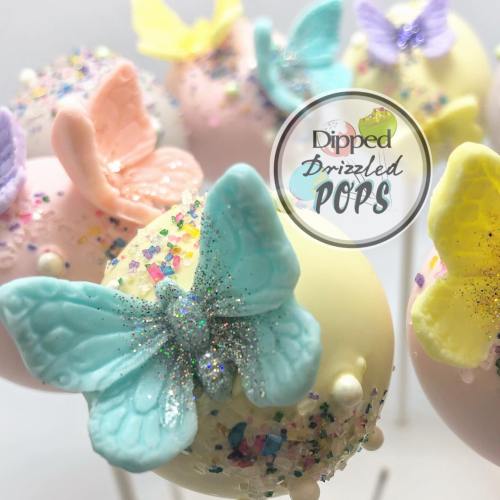 Colorful cake pops decorated with pastel butterflies and glitter, featuring a logo for "Dipped Drizzled Pops."