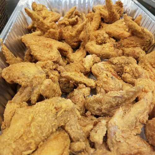 A tray filled with golden-brown, crispy fried chicken wings.