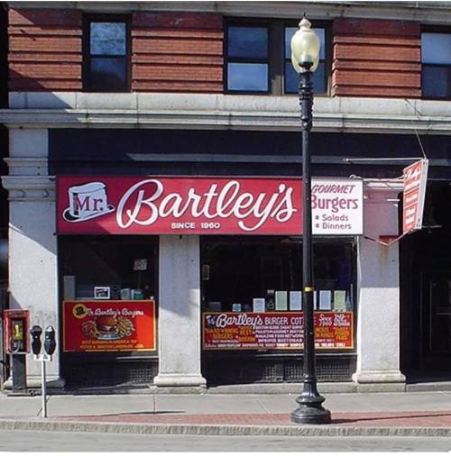 Exterior of Mr. Bartley's, a gourmet burger restaurant, featuring a red sign and menu displays.