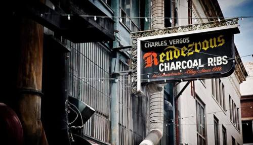 Sign for Charles Vergos Rendezvous, featuring "Charcoal Ribs" and "In Downtown Memphis Since 1948," against a city backdrop.
