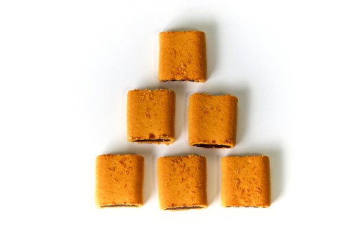 A pyramid arrangement of square cookies with a chocolate filling, set against a white background.