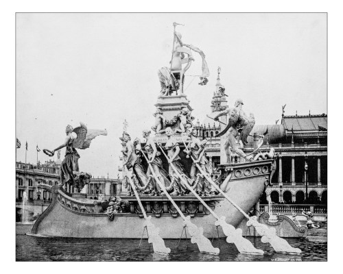 A historic black-and-white image of an ornate decorative boat with sculptures, set in a large body of water.