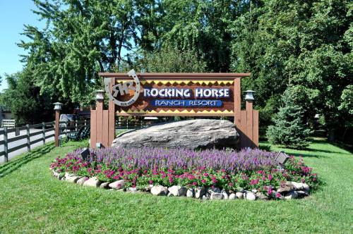 Sign for Rocking Horse Ranch Resort surrounded by colorful flowers and greenery.