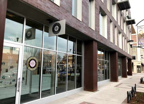 Exterior view of Scenic Route Bakery, featuring large glass windows and a modern brick facade.