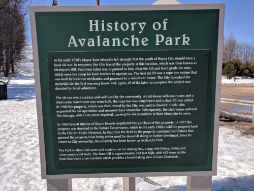 Sign detailing the history of Avalanche Park, including its development and community involvement in Boyne City.
