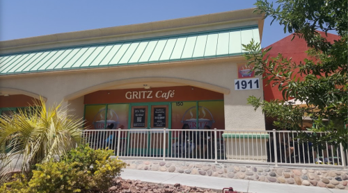 Exterior of Gritz Café, featuring a green roof, large windows, and a sign with the café's name and address.