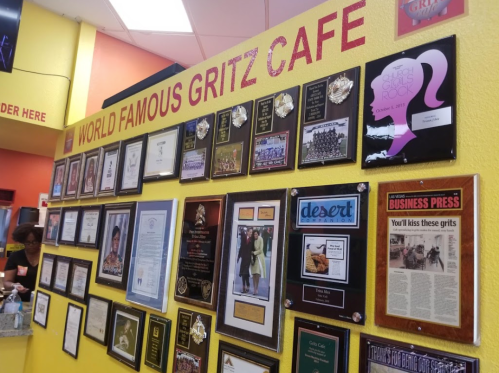 A colorful wall displaying various awards and recognitions for World Famous Gritz Cafe.