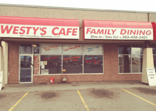 Exterior of Westy's Cafe, a family dining restaurant with red awnings, closed sign, and colorful window advertisements.