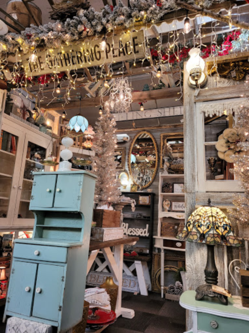 A cozy shop interior filled with vintage decor, twinkling lights, and charming furniture pieces.