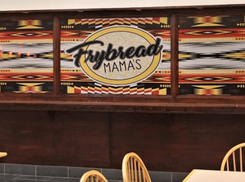 A colorful mural featuring the text "Frybread Mama's" with tribal patterns in a dining area.