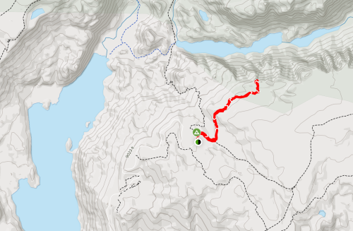 Map showing a terrain with a highlighted red trail, green marker, and surrounding water features.