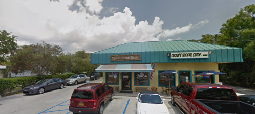 A storefront with a teal roof, featuring signs for "Craft Beer City" and "Cutter Street Hook," surrounded by parked cars.