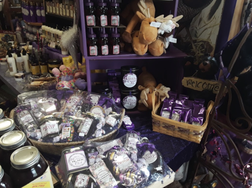 A colorful display of various products, including jars, plush toys, and bags, in a whimsical shop setting.