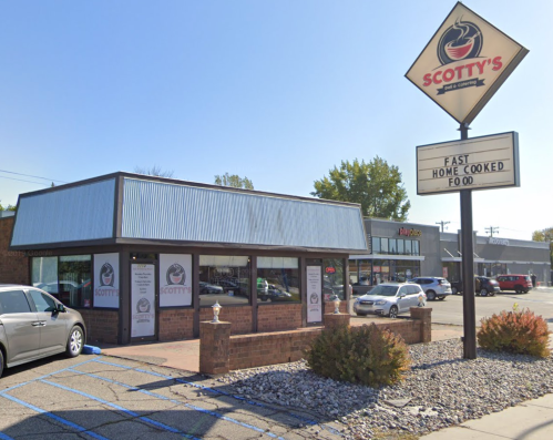 Exterior of Scotty's restaurant with a sign advertising "Fast Home Cooked Food" and nearby parking.