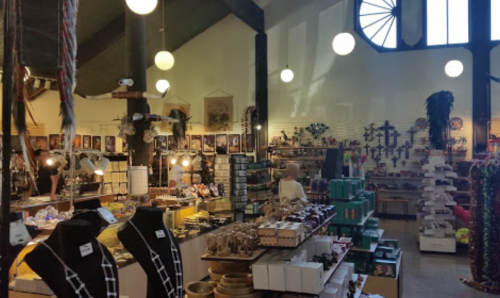 A vibrant shop interior filled with various crafts, jewelry, and decorative items, featuring unique displays and lighting.