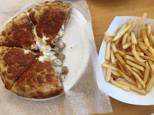 A plate with a few slices of cheesy pizza and a side of golden French fries.