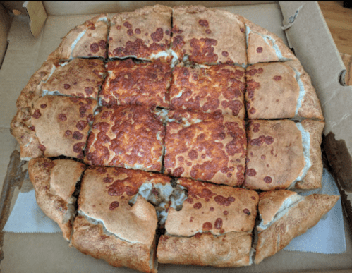 A freshly baked pizza with a golden crust, topped with melted cheese and cut into square slices, in a pizza box.