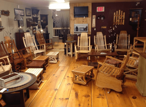 A cozy shop interior featuring various wooden rocking chairs and tables on a wooden floor.