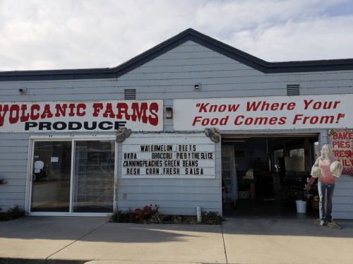 Exterior of Volcanic Farms Produce with a sign promoting fresh produce and baked goods. "Know Where Your Food Comes From!"