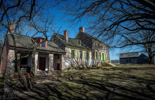 Historic buildings surrounded by bare trees under a clear blue sky, showcasing traditional architecture.