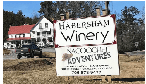 Sign for Habersham Winery and Nacoochee Adventures, featuring activities like ziplines, ATVs, and a challenge course.