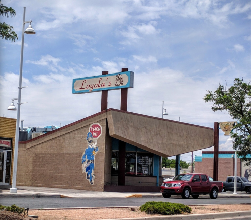 A retro-style building with a sign reading "Loyola's" and a mural of a cartoon character on the side.