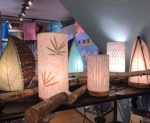 A display of unique lamps in various shapes and designs, featuring natural materials and soft lighting.