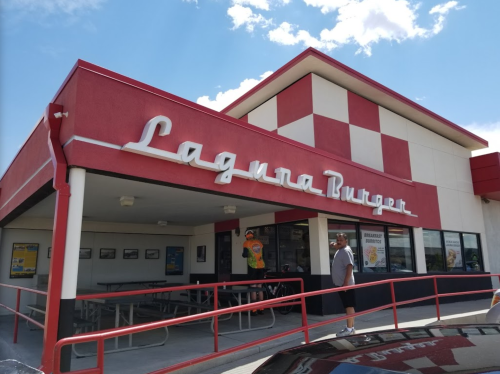 Exterior of Laguna Burger restaurant with red and white checkered design and a person standing outside.