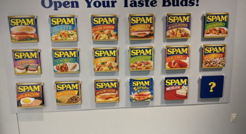 A display of various SPAM flavors, including Teriyaki, Jalapeño, and Bacon, with one mystery flavor.