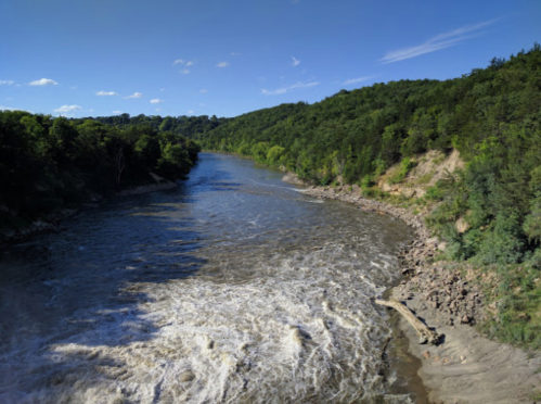 A winding river flows through a lush green landscape under a clear blue sky.