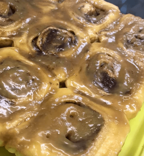 Close-up of a dessert featuring rolled dough with a glossy caramel glaze on top.