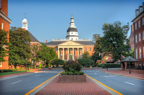Historic building with a dome, surrounded by trees and brick pathways, in a serene urban setting.