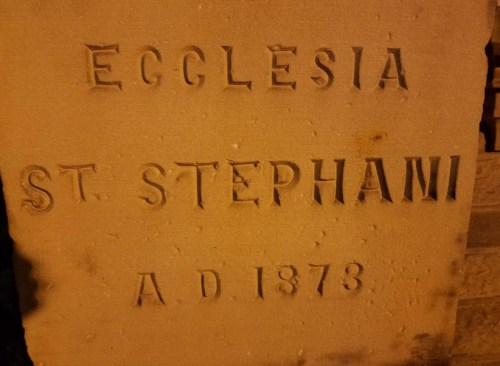 Stone inscription reading "Ecclesia St. Stephani A.D. 1873" with carved lettering.
