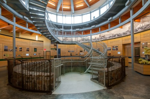 Interior view of a circular building featuring a spiral staircase and informational displays on the walls.