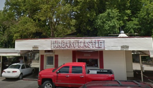 Exterior of Kream Kastle, a casual eatery with a red truck parked in front and trees in the background.