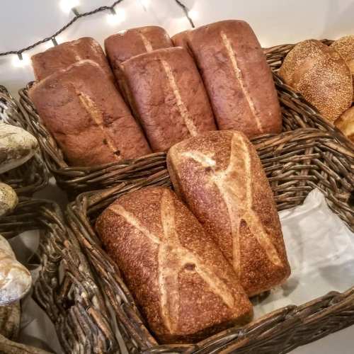 Freshly baked loaves of brown bread arranged in woven baskets, with a warm, inviting ambiance.