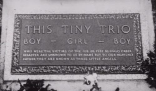 A memorial plaque reading "This Tiny Trio" honoring three children lost in the Buffalo Creek disaster of February 26, 1932.