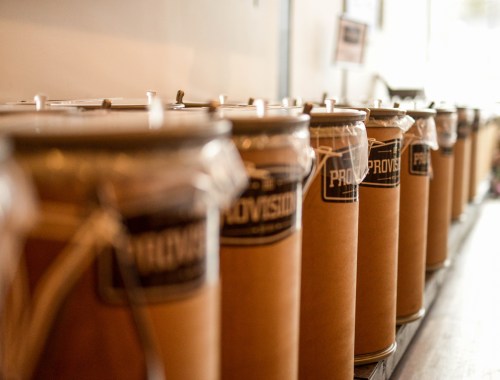 A row of sealed, labeled cans on a shelf, showcasing a variety of provisions.