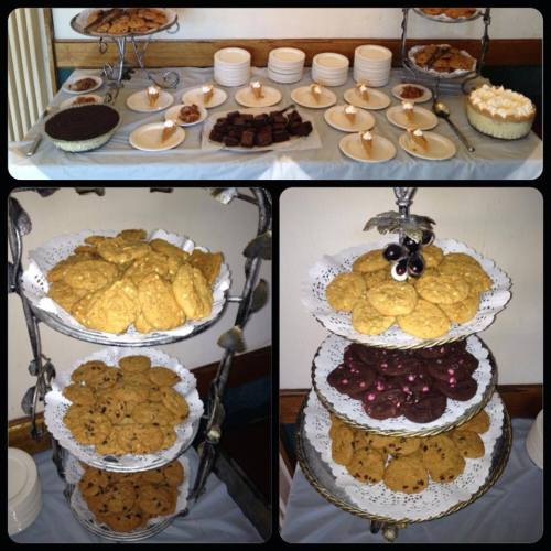 A dessert table featuring various cookies, brownies, and pie, arranged on tiered stands and plates.