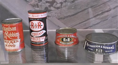 Four vintage canned food products from Richardson & Robbins, including chicken broth and boned chicken, displayed on a shelf.