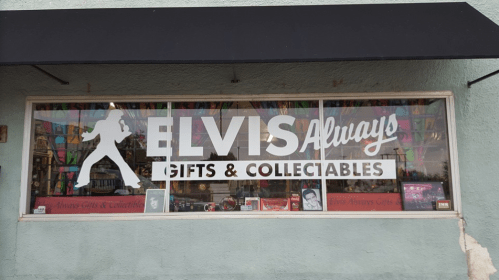 Storefront window displaying "Elvis Always Gifts & Collectables" with a silhouette of Elvis and colorful decorations inside.