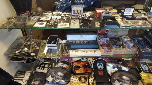 Display case filled with various Elvis-themed jewelry, accessories, and memorabilia.