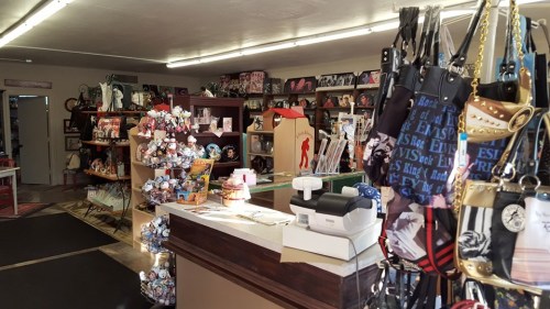 A cozy shop interior filled with various merchandise, including plush toys, books, and accessories, with a checkout counter.