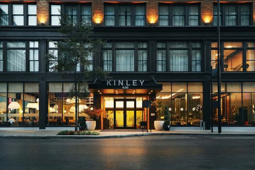 Exterior view of the Kinley hotel, featuring modern architecture, warm lighting, and a welcoming entrance.