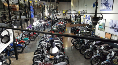 A spacious motorcycle museum filled with various vintage and modern bikes, displayed on multiple levels.