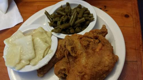 A plate of fried chicken with green beans and a side of creamy mashed potatoes.