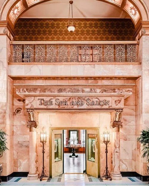 Elegant entrance to "The Spa and Salon," featuring ornate architecture and warm lighting.