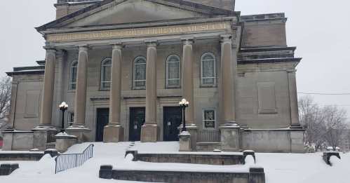 Snow-covered exterior of the Karpeles Manuscript Library Museum, featuring tall columns and a grand entrance.