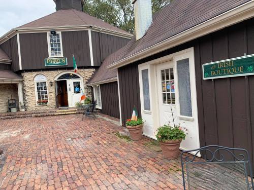 A charming outdoor view of a boutique with a brick pathway and a building featuring a sign for an Irish boutique.