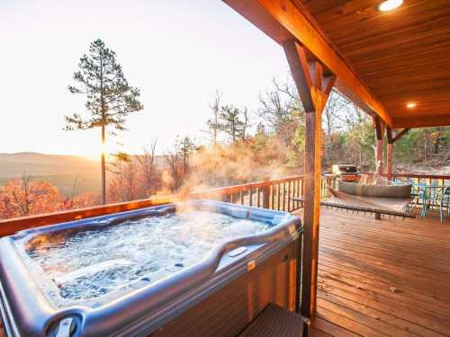 A hot tub on a wooden deck with a sunset view, surrounded by trees and a hammock in the background.